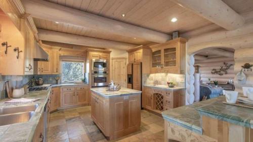 cocina grande con armarios de madera y encimeras de granito en Hot Tub Game Room Large Deck w Incredible View Penticton Lodge by AvantStay, en Big Bear Lake