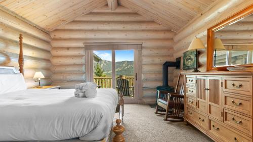 Un dormitorio con una cama en una cabaña de troncos en Hot Tub Game Room Large Deck w Incredible View Penticton Lodge by AvantStay, en Big Bear Lake