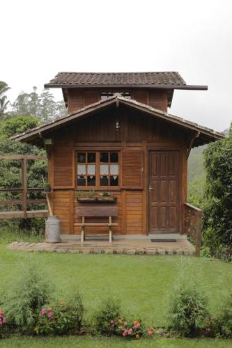 Sítio Reichart Atlantic Forest Retreat في ماريشال فلوريانو: كابينة خشبية صغيرة يوجد امامها مقعد