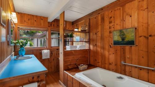 a bathroom with a large tub and wooden walls at The Pilot House by AvantStay Stunning Home Right On Arch Cape Beach in Arch Cape