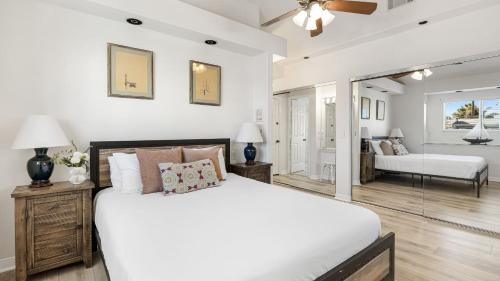 a white bedroom with a bed and a living room at Canalfront Charmer by AvantStay Waterfront w Shared Dock Hot Tub in Newport Beach