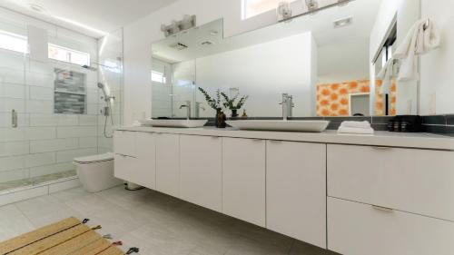 Casa Piña by AvantStay Vibrant Palm Springs Oasis w Colorful Stylish Design في لا كينتا: حمام أبيض مع مغسلتين ودش