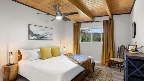 a bedroom with a bed and a ceiling fan at Hot Tub Fire Pit Deck Views Near the Lake The Matterhorn Manor by AvantStay in Crestline