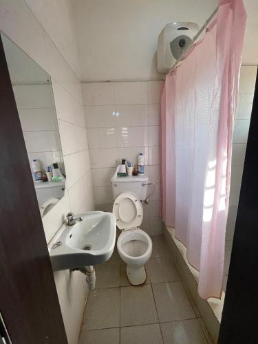 a bathroom with a toilet and a sink at Modern 1 Bedroom Apartment with Balcony in Enugu