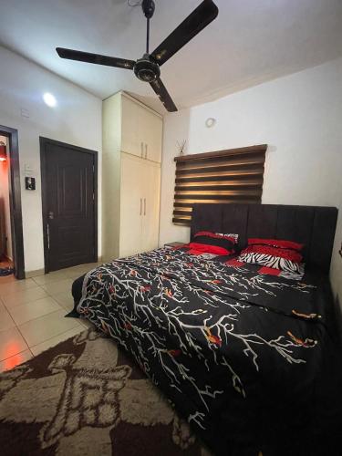 a bedroom with a large bed with red pillows at Modern 1 Bedroom Apartment with Balcony in Enugu