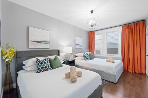 a bedroom with two beds and an orange curtain at Urban Charm | Near EWR Airport Easy Access to NYC in Newark