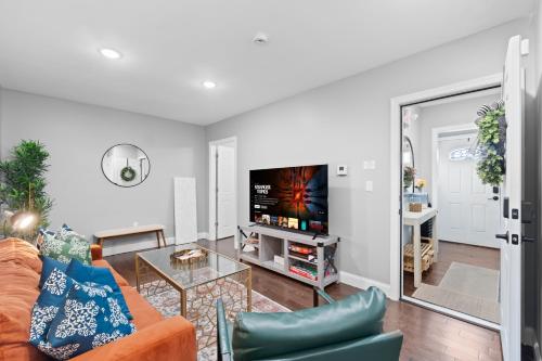 a living room with a couch and a tv at Urban Charm | Near EWR Airport Easy Access to NYC in Newark