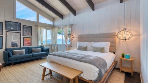 a bedroom with a large bed and a blue couch at Lakeview by AvantStay Private Waterfront Cabin on Lake Tahoe w Hot Tub Views in Tahoe Vista