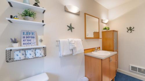 un baño con lavabo y espejo en Walk to Beach Relax in Hot Tub Dine on the Deck LoLis Place by AvantStay, en Arch Cape