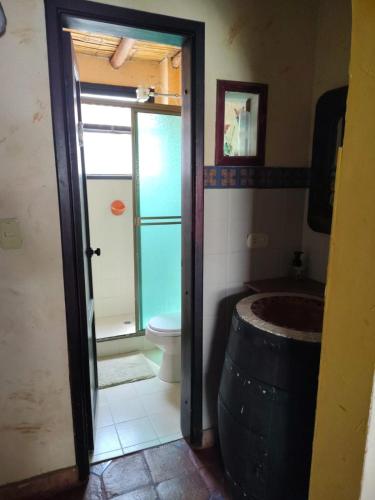 a bathroom with a toilet and a large barrel at Solue in Duitama