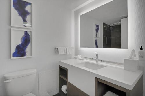 World of Blue 724 Beautiful QQ Hotel Rooms في سيكوكس: حمام أبيض مع حوض ومرآة