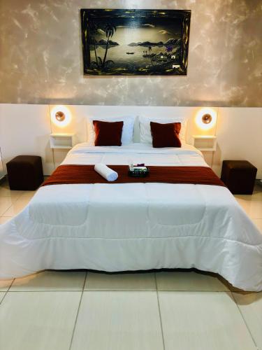 a bedroom with a large white bed with red pillows at Hospedagem Marechal 03 in São Roque