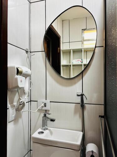 a bathroom with a mirror and a toilet and a sink at Hospedagem Marechal 03 in São Roque