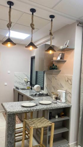 cocina con encimera con 2 sillas y mesa en Central studio, en Kenitra
