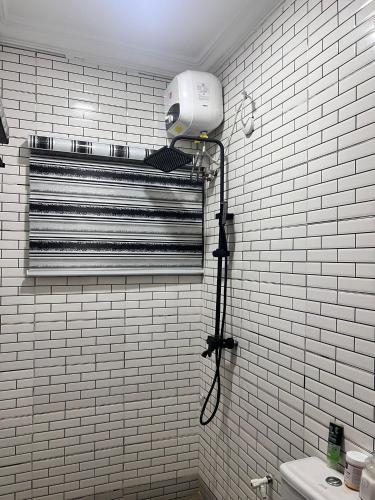 a white bathroom with a blow dryer on a wall at Podium Empire in Lekki