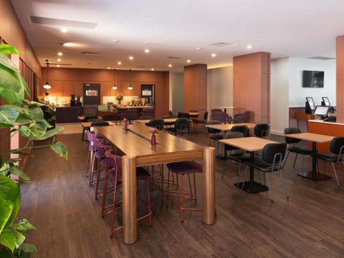 Un restaurante con mesas y sillas en una sala. en Mercure Newcastle, en Newcastle