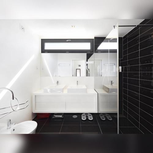 a white bathroom with two sinks and a mirror at Jardins da Parede Villa in Parede