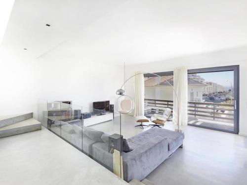een woonkamer met een bank en een groot raam bij Jardins da Parede Villa in Parede