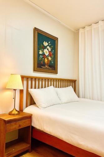 een slaapkamer met twee bedden en een schilderij aan de muur bij new홍대 연남동 아늑한 감성숙소#최대4인#연트럴파크#짐보관#올리브영 in Seoul