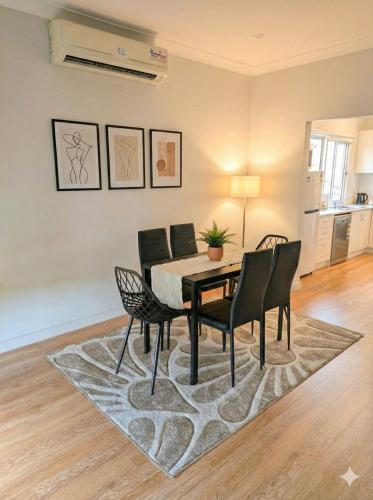 a dining room with a table and chairs at Huge 3Bed House and Backyard & 4 Car Park spaces and Near Parramatta in Wentworthville