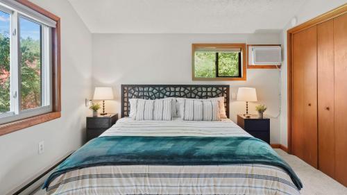 Waterside Haven by AvantStay Lakefront Hot Tub Game Room Fire Pit في Long Pond: غرفة نوم بسرير كبير ونافذتين