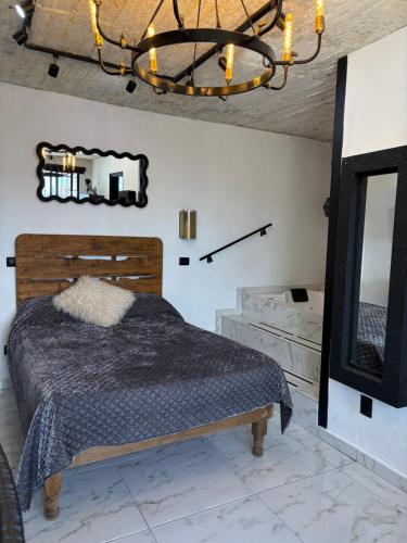una camera da letto con un letto e un lampadario di Secrect Jacuzzi Studio a San Miguel de Allende