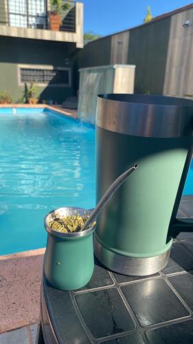 a pot of food sitting on a table next to a pool at Alojamiento Napoleon in Puerto Iguazú