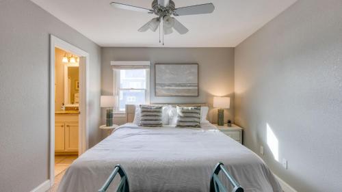 Sleeps 28 Beachfront w Pool Hot Tub Game Room Atlantic Watch by AvantStay في كيل ديفيل هيلز: غرفة نوم بها سرير ومروحة سقف