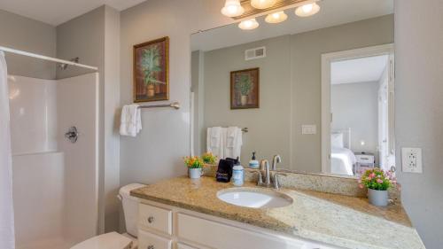 Sleeps 28 Beachfront w Pool Hot Tub Game Room Atlantic Watch by AvantStay في كيل ديفيل هيلز: حمام مع حوض ومرآة