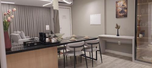 a kitchen with a counter with stools and a counter top at Flat Infinity 1504 Vista Mar in Itapema