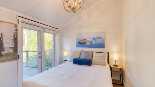 a white bedroom with a bed and a window at Cozy Whidbey Island Stay Steps to the beach Fireplace BBQ Near Trails in Freeland