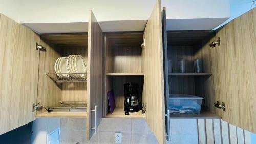 a kitchen with a cupboard filled with dishes at Refugio de la cordillera in Armenia