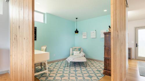 a room with blue walls and a desk and a chair at Chic Whidbey Island Waterfront Home w Hot Tub Firepits Views in Coupeville