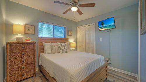 a bedroom with a bed and a ceiling fan at Stylish 2BR Coastal Getaway w Pool Prime Location Lazy Fun in Port Aransas
