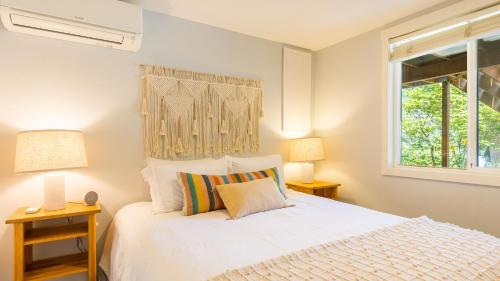 a bedroom with a white bed and two lamps at Mid-Century Beach Cabin by AvantStay Walk to Beach in Coupeville