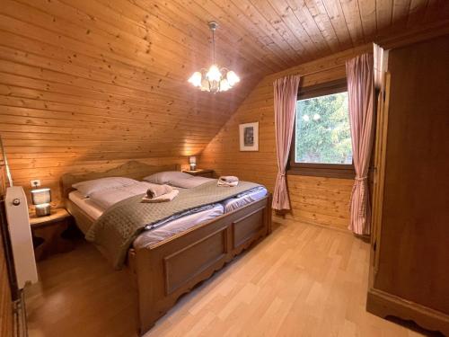 a bedroom with a bed in a wooden cabin at Mooshausl in Gnesau