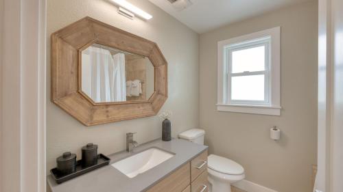 a bathroom with a sink and a toilet and a mirror at Chic Sonoma Oasis w Pool Bocce Hot Tub Minutes to Downtown in Sonoma