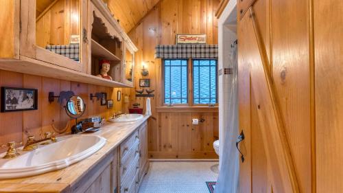 baño con 2 lavabos y paredes de madera en Homewood Lakefront by AvantStay Private Beach Lake Access Views, en Homewood