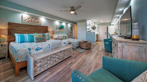 a bedroom with a bed and two chairs at Beachfront Condo Prvt Balcony w View Pool Access Beach Happy by AvantStay in Port Aransas