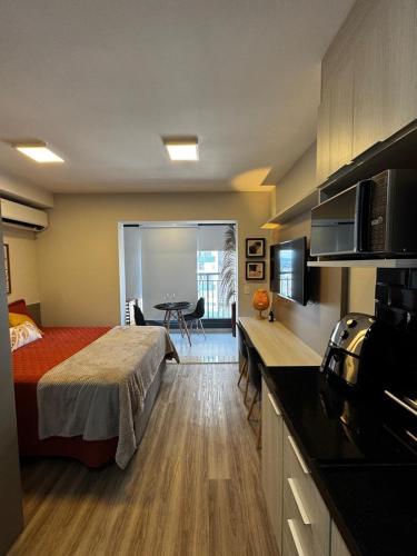 a hotel room with a bed and a kitchen at Studio Metrô Tucuruvi in São Paulo