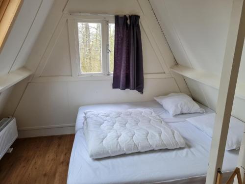 uma cama num pequeno quarto com uma janela em Peaceful Ardennes Getaway for 4 Guests em Septon