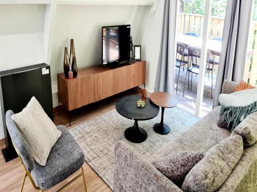 uma sala de estar com um sofá e uma TV em Tranquil Countryside Stay in Durbuy em Septon