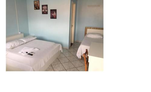 Una habitación con dos camas y una mesa dentro. en Hotel BR, en Videira