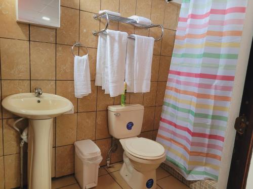a bathroom with a toilet and a sink at El hostal de Uriel in Izalco