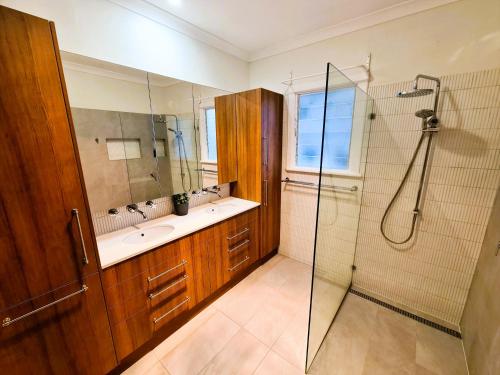 een badkamer met een douche en een wastafel bij Jarrah Cottage in Waroona