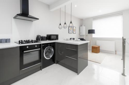 a kitchen with a washing machine and a sink at The Fratton Apartment with parking in Portsmouth