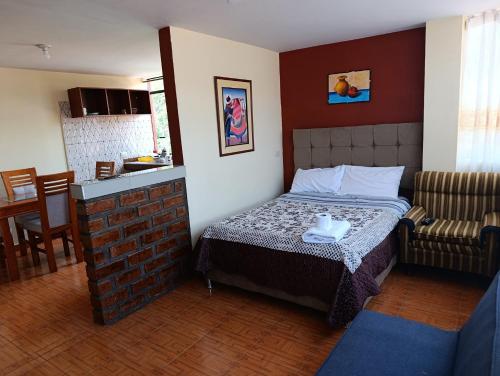a small bedroom with a bed and a couch at Hostal Ayllu con cochera in Urubamba