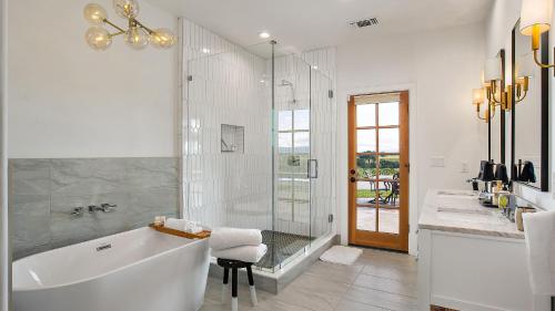 a white bathroom with a tub and a glass shower at Wellsona Vineyard Retreat Pool Hot Tub Views Main Home Guest Home in Paso Robles