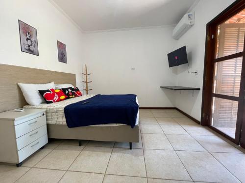 イーリャ・コンプリーダにあるCasa Triunfoのベッドとテレビのある寝室