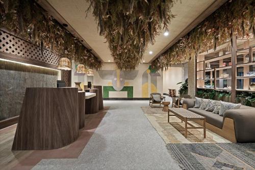 a lobby with couches and tables and plants at Hotel Indigo Playa del Carmen by IHG in Playa del Carmen